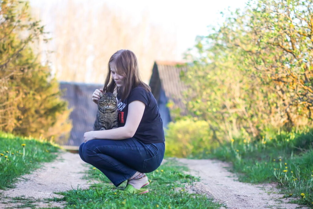 A teen girl is playing with her cat