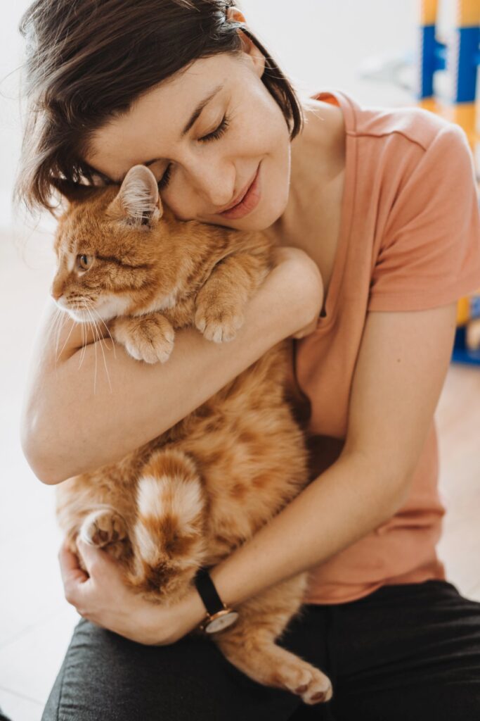 A woman is hugging her beloved Maine Coon cat
