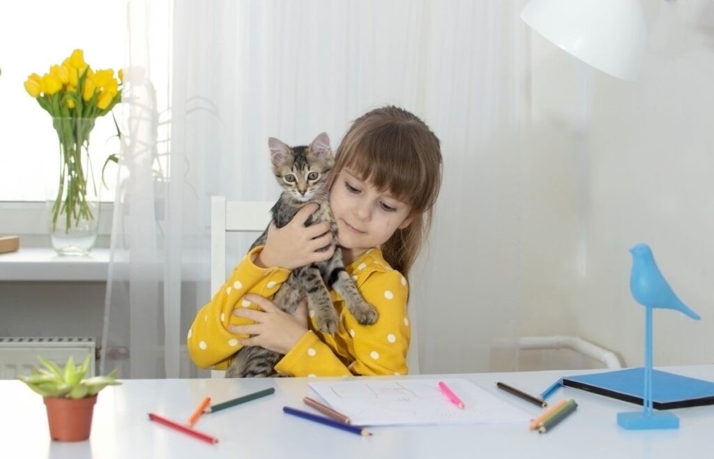 Girl holding cat in her room