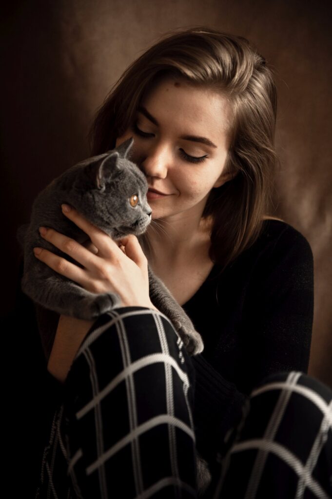 A beautiful girl hugs a cat